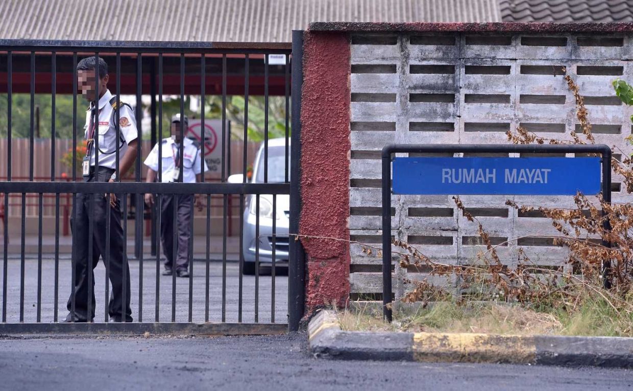 Security personnels standing guard at the Kajang Hospital mortuary where victims killed in a  fire in Sungai Long was brought to, Wednesday, December 13, 2017. RAJA FAISAL HISHAN/The Star.