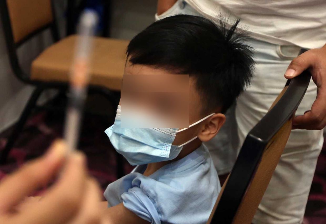 A boy watching the syringe filled with Pfizer vaccine during the National Covid-19 Immunisation Programme for Children (PICKids) at Shah Alam Ideal Convention Centre (IDCC) yesterday. — IZZRAFIQ ALIAS/The Star