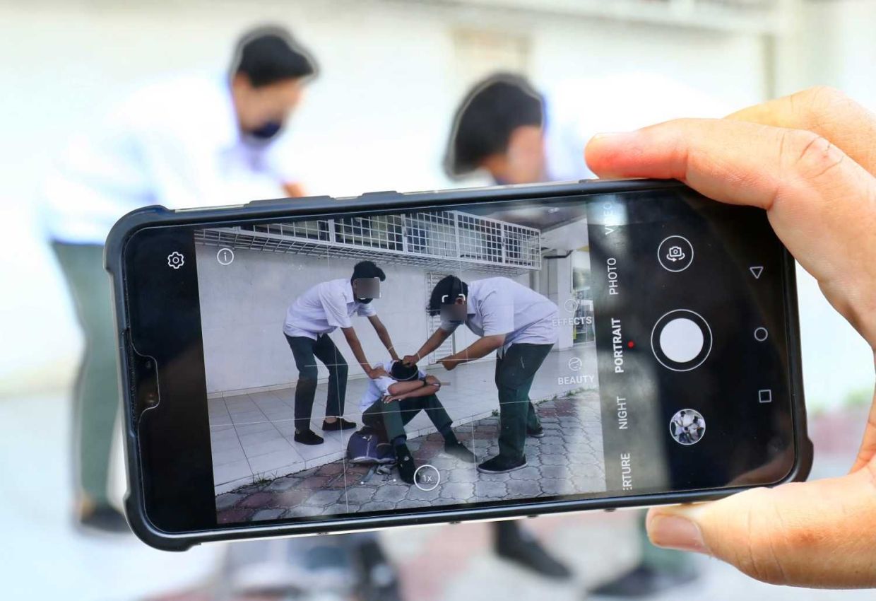 Story on student bully incident, picture showing a few student are bullying a other student while recording the incident. Just posing photo by model. — FAIHAN GHANI/The Star