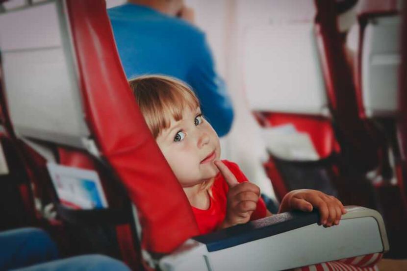 child safety in flight, cute little girl flying by plane, patient kid ready to take off