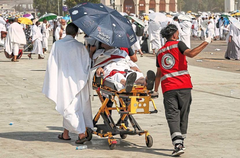 TOPSHOT - Medical team members evacuate a Muslim pilgrim, affected by the soarching heat, at the base of Mount Arafat, also known as Jabal al-Rahma or Mount of Mercy, during the annual hajj pilgrimage on June 15, 2024. Friends and family searched for missing hajj pilgrims on June 19 as the death toll at the annual rituals, which were carried out in scorching heat, surged past 900. (Photo by Fadel SENNA / AFP)