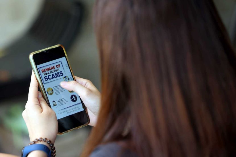 People looking for an unknown bank account on their phone, a notice appear warning them to beware of mule account scams.Posing pictures of people looking at Bank Account on PC or Handphone.Story on Scam.( FEB 26 2023) — ART CHEN/The Star