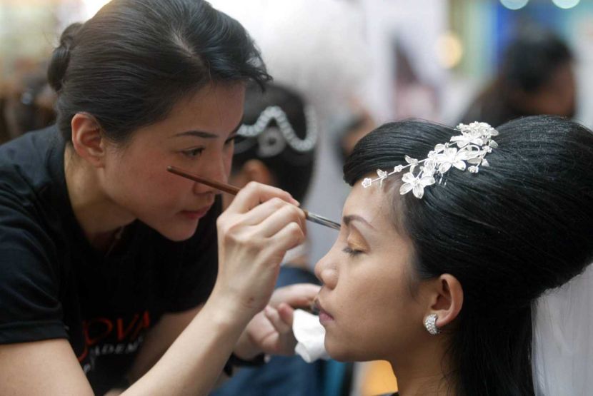 Artistic: A student carefully applying makeup on her 'bride' modelat The Nova Makeup Academy Sdn Bhd's graduation ceremony cum bridal makeup competition held at IOI Mall in Puchong. *** Local Caption *** Artistic: A student carefully applying make-up on her model. Students at The Nova Makeup Academy learn not just make-up skills but also hair styling.