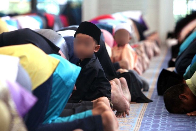Solemn prayers!A boy looking on curiously while conducting the morning prayers during Hari Raya Haji Al- Adha at Sultan Azlan Shah Mosque Ipoh.RONNIE CHIN/The Star