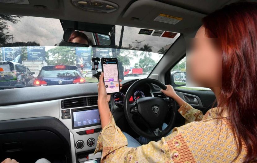 A women driving while using a mobile phone. Traffice police will strictly enforce the law againtsmotorists caught using their handphone while driving.(17/7/2023). —AZHAR MAHFOF/The Star
