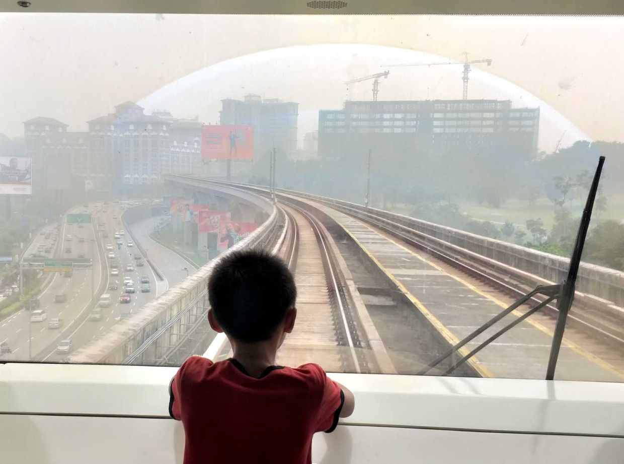 Blanketed by haze.A boy looking out the window of MRT. P.Nathan/The Star
