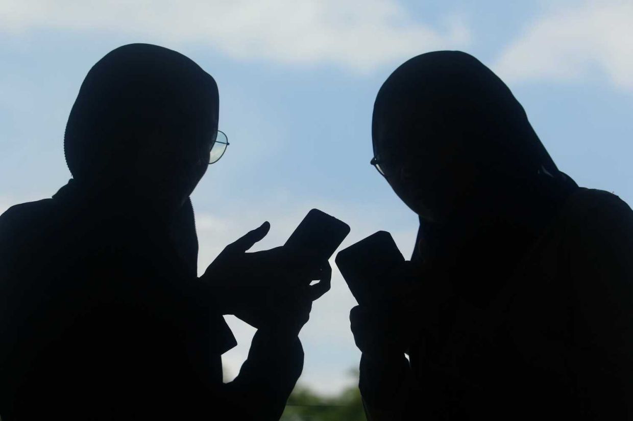 People using social media applications through mobile phone. Story on avoid social media scam. — FAIHAN GHANI/The Star