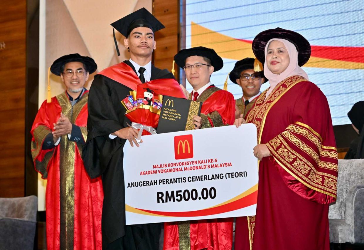 Rubiah menyampaikan anugerah kepada salah seorang pelajar cemerlang yang berjaya menamatkan pengajian di Akademi Vokasional McDonald’s.