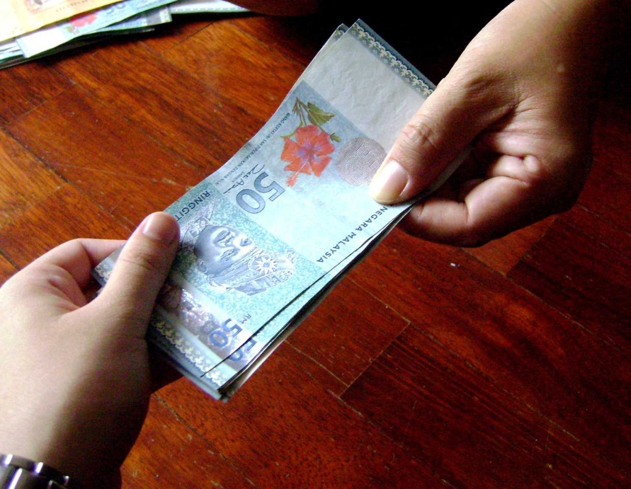 Penggunaan duit palsu adalah satu kesalahan jenayah. -Gambar hiasan AI