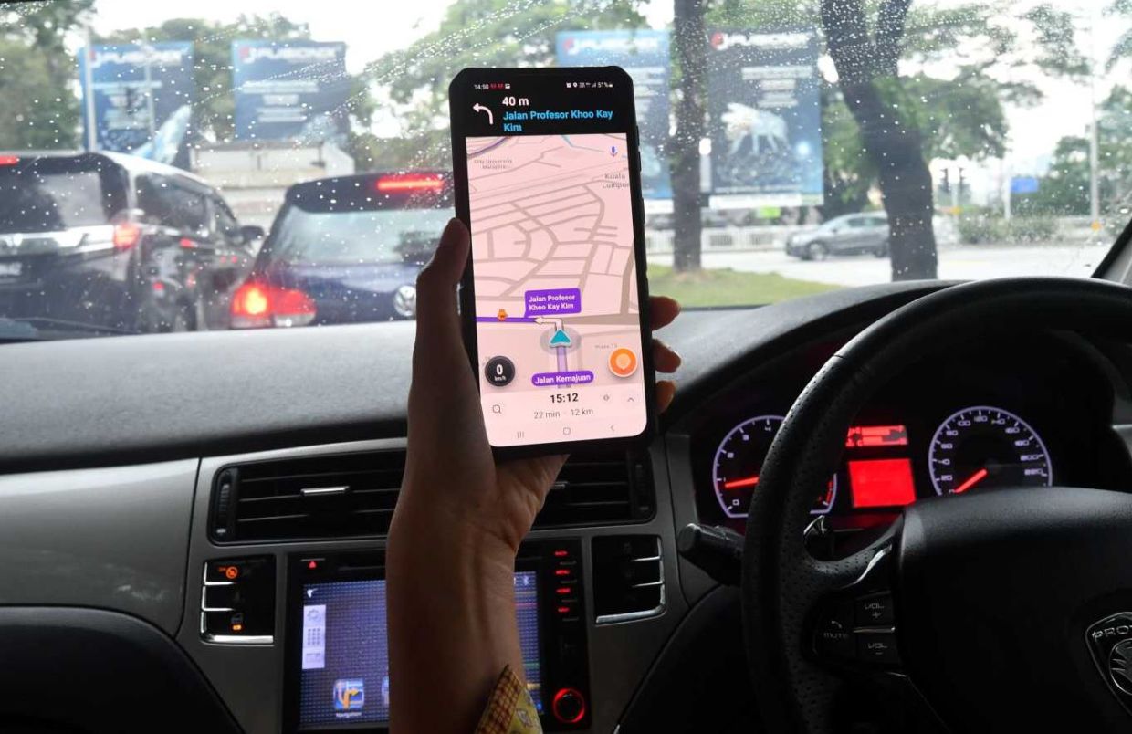 A women driving while using a mobile phone. Traffice police will strictly enforce the law againtsmotorists caught using their handphone while driving.(17/7/2023). —AZHAR MAHFOF/The Star