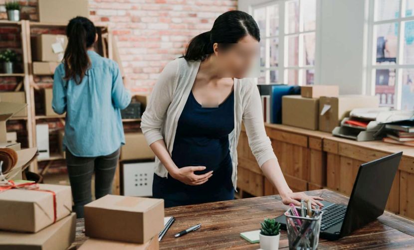 Group of young Asian women working on small business startup at office online marketing shopping and packaging delivery. two female freelance teamwork concept. pregnant lady employee using laptop pc.