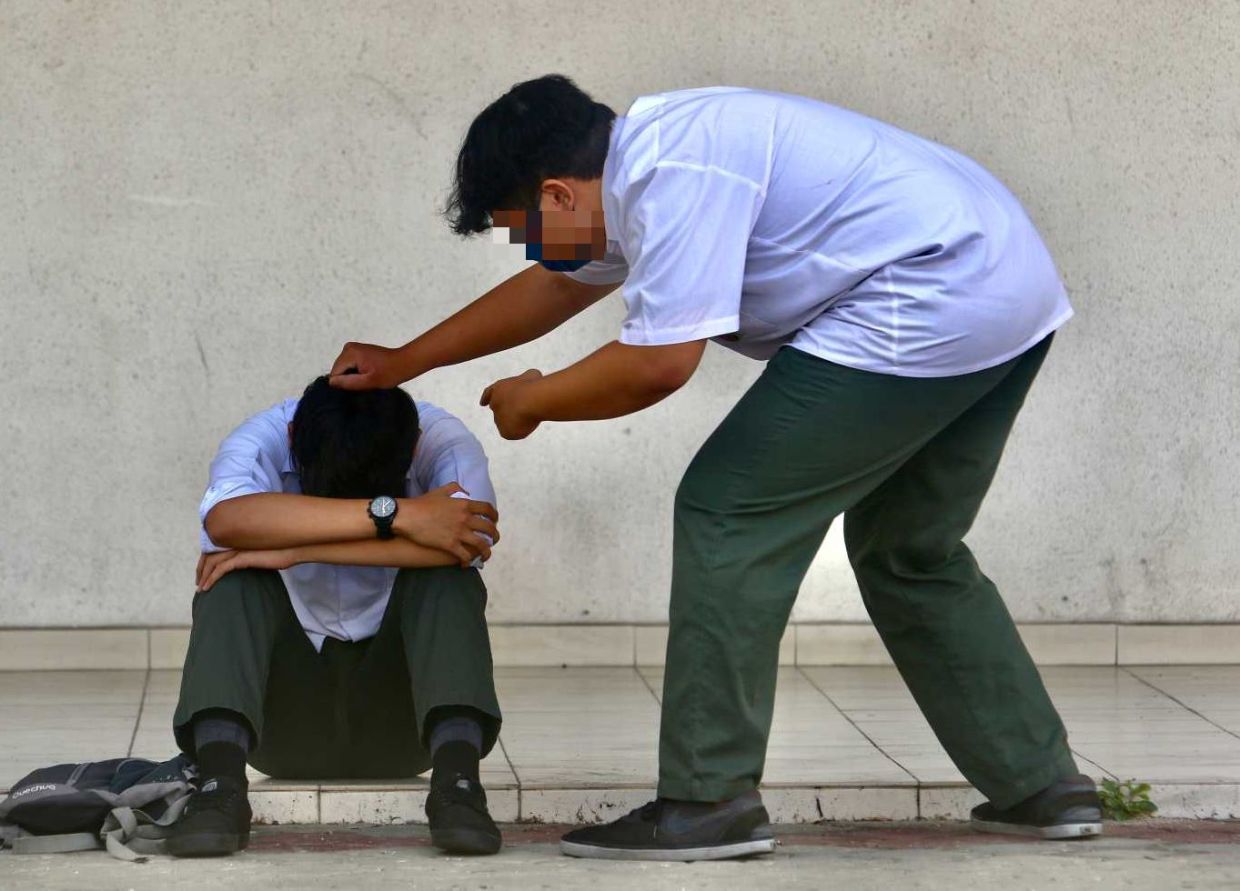 Story on student bully incident, picture showing a few student are bullying a other student while recording the incident. Just posing photo by model. — FAIHAN GHANI/The Star