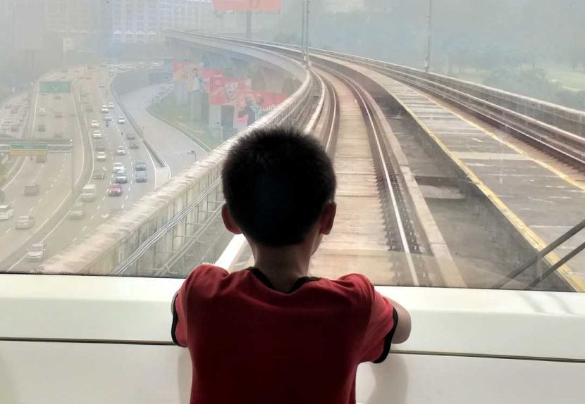 Blanketed by haze.A boy looking out the window of MRT. P.Nathan/The Star