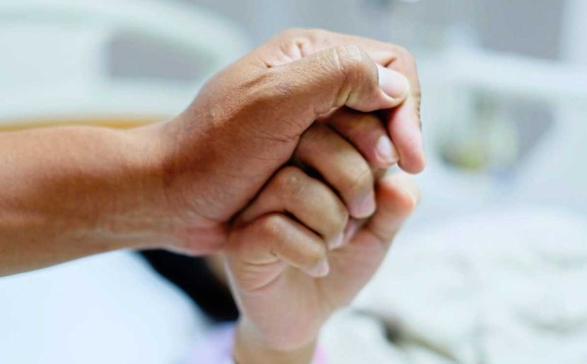 Close up focus on the Shake hands of a patient sick encourage encouragement on the bed in hospital ward. Healthcare concept.