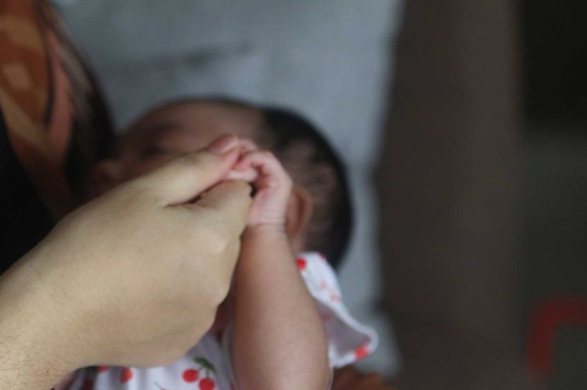 A women receive the baby at her house, story on adopting baby online. Pose by model. — FAIHAN GHANI/The Star