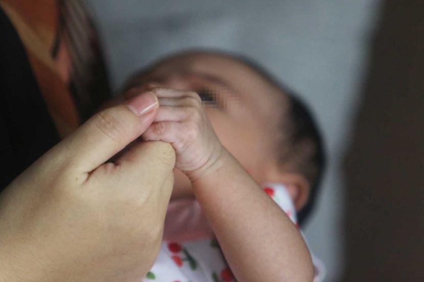 A women receive the baby at her house, story on adopting baby online. Pose by model. — FAIHAN GHANI/The Star