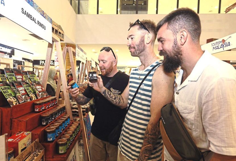 A group of foreign tourists admiring the sambal being displayed at one of the booths during the Cuti-Cuti Malaysia Carnival at Kuantan City Mall, Pahang on Sept 19. — AZLINA ABDULLAH/The Star