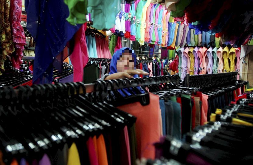 KUALA TERENGGANU 28 JUNE 2015: A young Muslim busy selecting through a collection of scarves to be worn during Hari Raya at the ramadan bazaar located in Terengganu Trade Center (TTC) in here. (STAND ALONE PIX)zabidi tusin/the star/terengganu