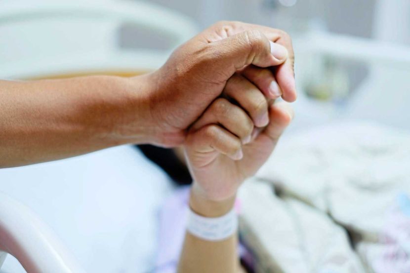 Close up focus on the Shake hands of a patient sick encourage encouragement on the bed in hospital ward. Healthcare concept.