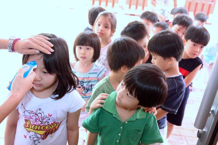 Pupils of Tadika Juara Cerdik go through a temperature check every morning before they are allowed to enter the school compound as part of the school's A(H1N1) precautionary measures.