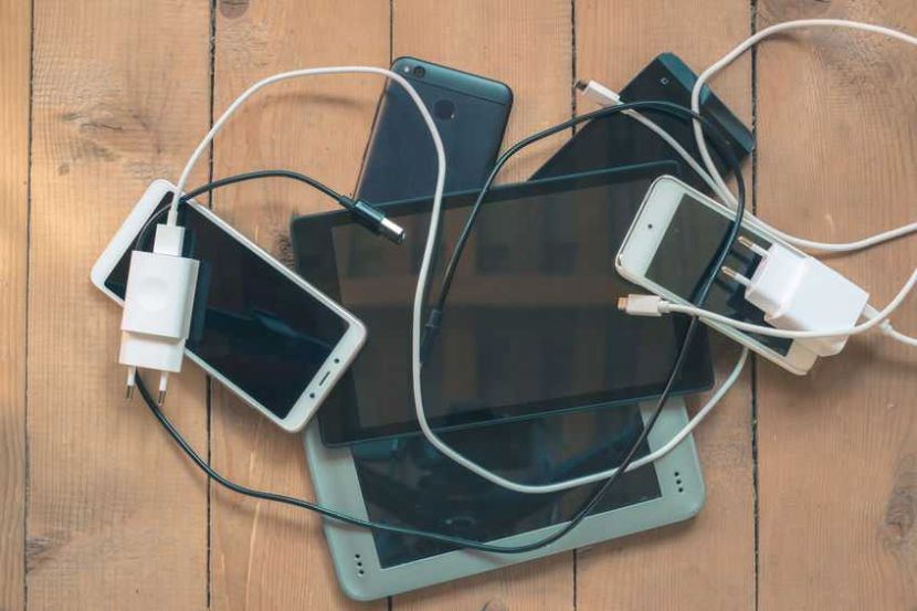 Group electronic devices and office equipment. Smartphones, tablet, eBook, battery charger. Many gadgets, addiction concept. High quality photo