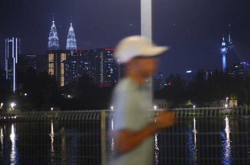 A man is seen jogging at Tasik Titiwangsa with the Kuala Lumpur views as background during the Covid-19 positive cases reported high recently.—AZMAN GHANI/The Star