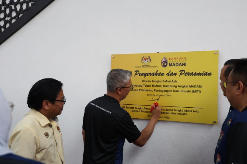 Tengku Zafrul menandatangani plat perasmian Dewan Serbaguna Terbuka Kampung Tebuk Mufrad pada Sabtu.