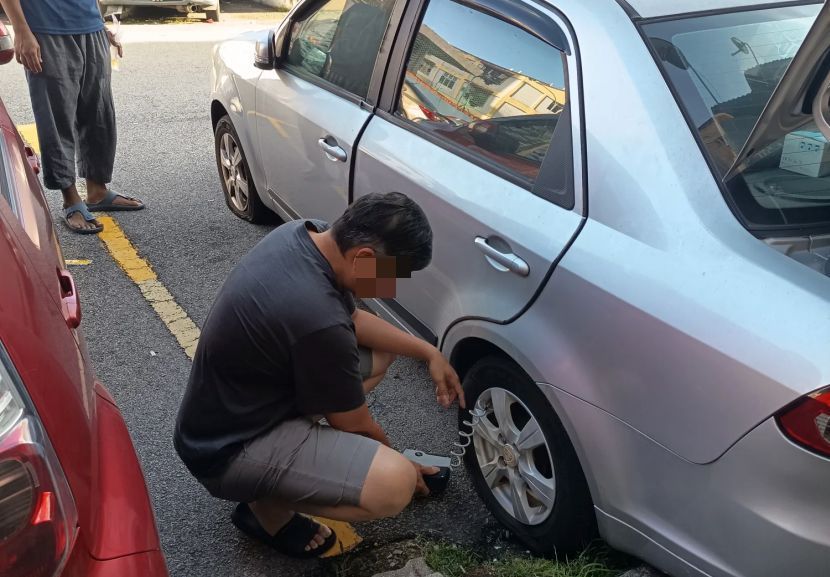 Jirannya membantu mengepam tayar kereta yang telah pancit.