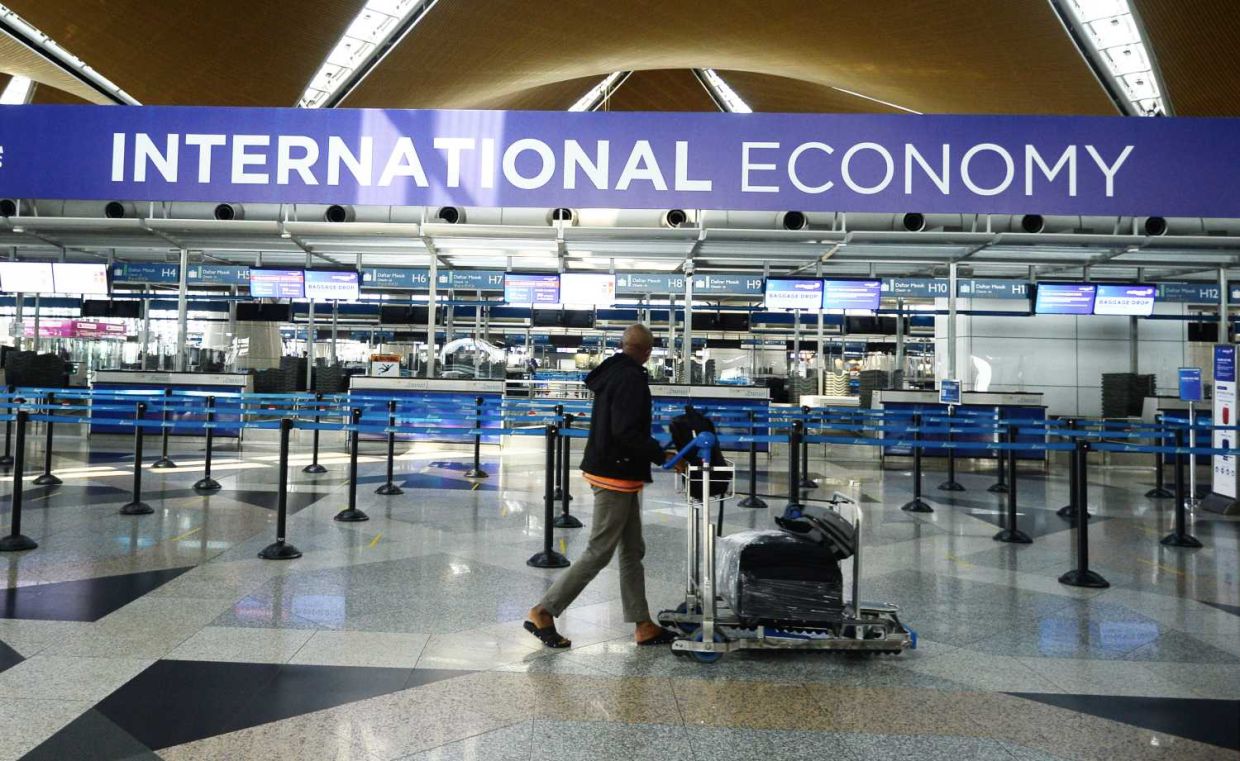 A traveler pusha trolley past International check in counter at KLIA. Travel ban imposed people from 23 conutries with high number of Covid-19.AZHAR MAHFOF/The Star (8/9/2020).