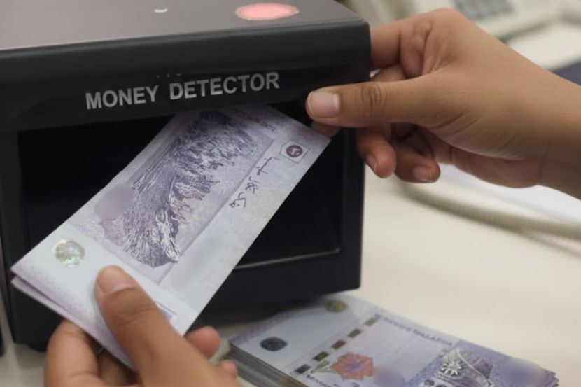 Mesin pengesan wang membantu ketulenan wang kertas. -Gambar hiasan AI