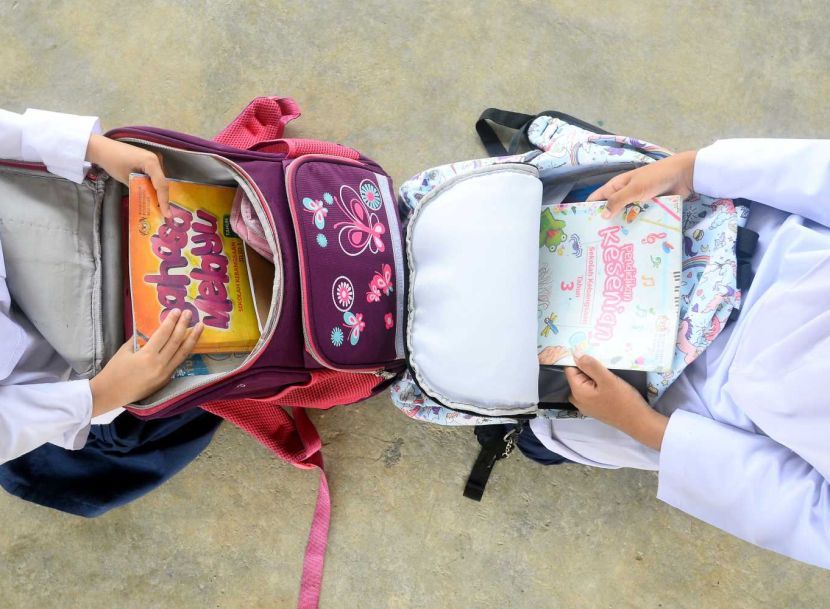 Primary school students arranging books into their bags . Story on reduce of books in students schools bags. (14/4/2022). —AZHAR MAHFOF/The Star