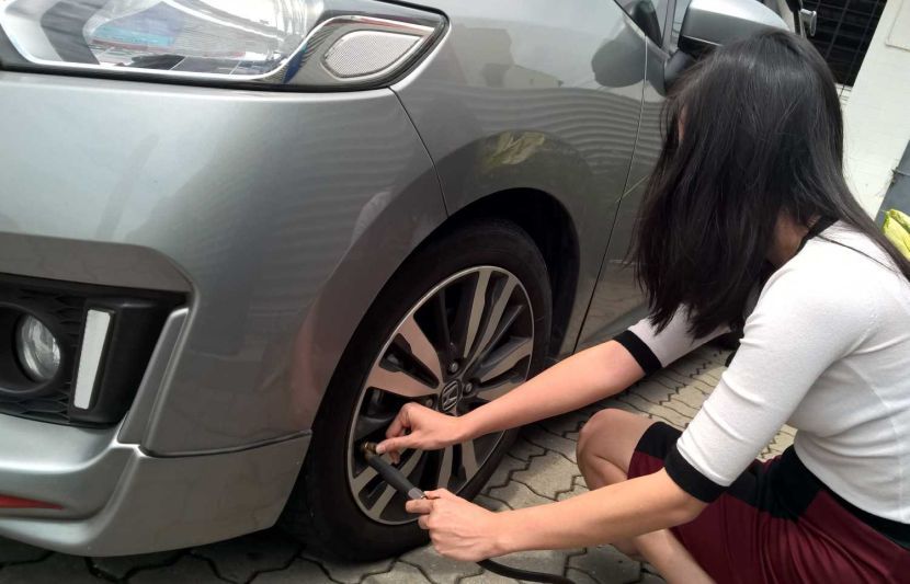 Motosist checking the tyre pressure.