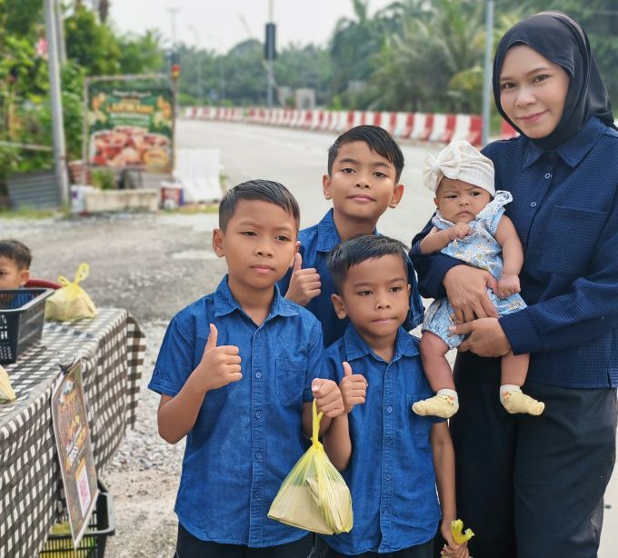 Nadiatul bersama empat daripada lima anaknya ketika berniaga nasi lemak.