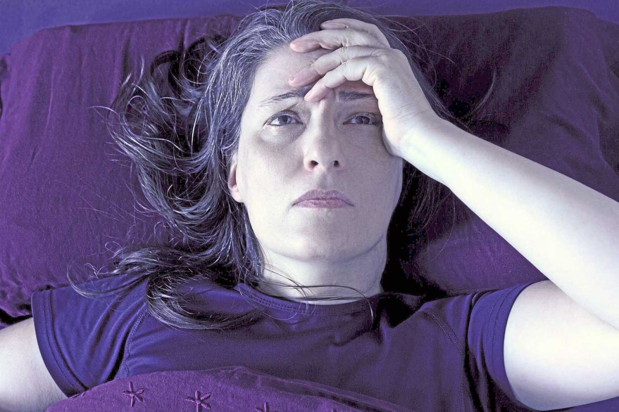 In a new study, researchers have found that the hot flashes and night sweats experienced by many middle-aged women may be linked to a higher risk of obstructive sleep apnea. (Dreamstime)