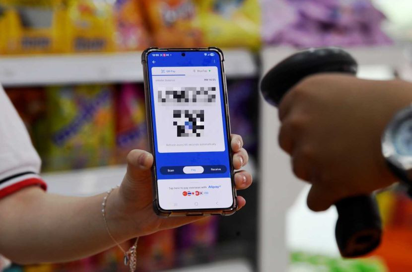 A women displays her e-wallet Qr code as she cashless payment at an conviences shopin Petaling Jaya.Cashless payments are surging globally and in Malaysians using e-wallets,especially among younger demographics. Please blur number and qr code .—AZHAR MAHFOF/The Star.