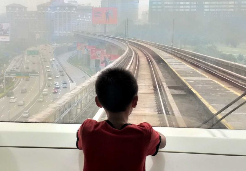 Blanketed by haze.A boy looking out the window of MRT. P.Nathan/The Star