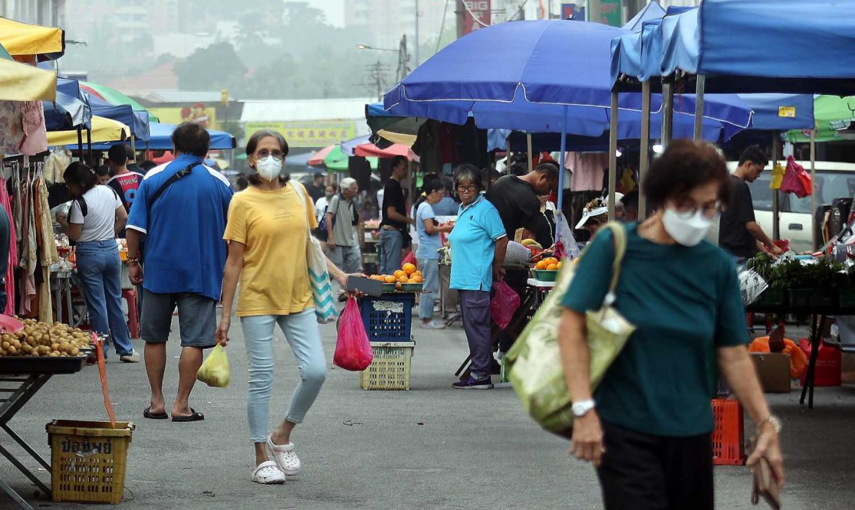 Some shoppers at Taman Eng Ann morning market wear face masks as haze conditions worsen across Selangor, with several areas recording unhealthy air quality levels.— KK SHAM/The Star