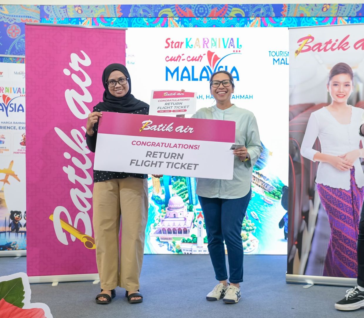 Pengunjung menerima hadiah tiket penerbangan pergi balik tajaan Batik Air pada sesi penyampaian hadiah sempena Star Karnival Cuti-Cuti Malaysia. 