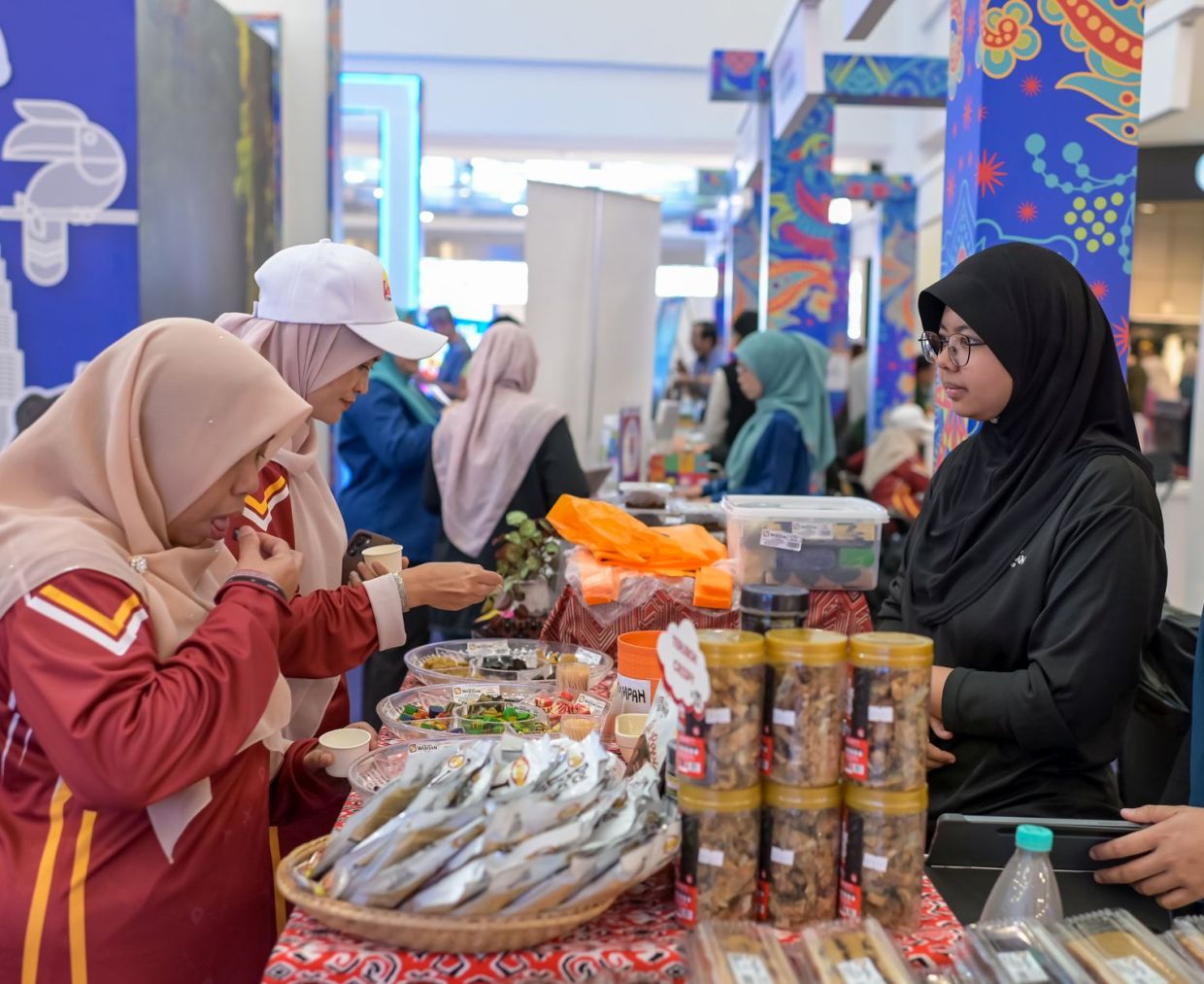 Pengunjung melihat dan mendapatkan maklumat mengenai produk makanan tempatan yang ditawarkan oleh pempamer di Star Karnival Cuti-Cuti Malaysia. 